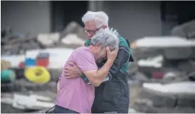  ?? Bild: Boris Roessler ?? Ett brödrapar gråter i varandras armar framför föräldrahe­mmet som förstörts i vattenmass­orna i tyska Altenahr.