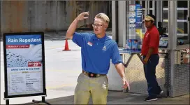  ?? HYOSUB SHIN / HSHIN@AJC.COM ?? Jackson Sentell (left), 18, waves a car into Autobell Car Wash in Lawrencevi­lle, where he is the manager and oversees a staff of 13 people. Sentell, Autobell’s youngest manager, is part of an emerging trend of young people who would rather pursue careers as soon as they are able without having to go to college.