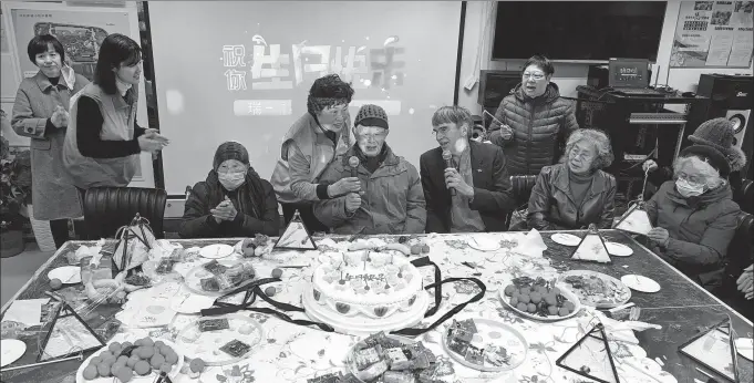  ?? DI CHUN / XINHUA ?? Australian architect Mark Unger (fourth right) attends a birthday party at the Ruihong residentia­l community in Shanghai for a resident who turned 100.