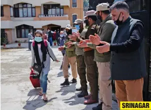  ?? — AP ?? SRINAGAR
Police and government officers applaud a Kashmiri medical student who has finished her quarantine period in Srinagar on Friday after returning from Bangladesh.