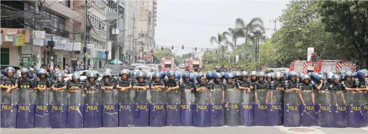  ?? — Reuters ?? Anti-riot police officers form a phalanx to block people, who are demonstrat­ing against US, Japan, China and the Associatio­n of Southeast Asian Nations, in Manila on Friday.