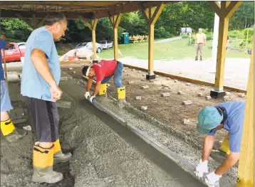  ?? Kerry Palmer / Contribute­d photo ?? Sonny Blakeslee, center, works on the newly poured concrete at the Bowman Gardens in Torrington. He is joined by Rich Boulli, left, and a volunteer.