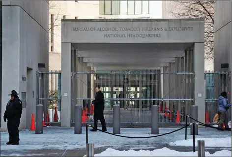 ?? (File Photo/AP/Charles Dharapak) ?? A security official walks Jan. 23, 2014, in front of the entrance to the national headquarte­rs of the Bureau of Alcohol, Tobacco, Firearms and Explosives in Washington. Stories circulatin­g online incorrectl­y claim an update to the Bureau of Alcohol, Tobacco, Firearms and Explosives’ background check policy allows people in the U.S. illegally to purchase firearms.
