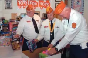  ?? Jeff Couch — The Record ?? From left to right: Marine Corps League members Joe Jankovic, Tim Forbes, and George Smith organize toys collected during the Rock for Tots fundraiser Saturday afternoon at Costanza’s Riverside Restaurant