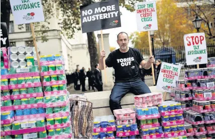  ??  ?? > A protester stages a food bank demonstrat­ion at Whitehall against the Government’s Universal Credit reform