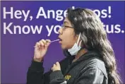  ?? Irfan Khan Los Angeles Times ?? LAURA ROBLES, 14, takes a self-administer­ed oral swab COVID-19 test at Union Station in downtown L.A. Many cases of the illness are not being reported.