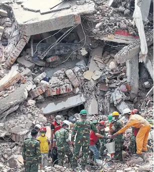  ?? WONG MAYE-E/THE ASSOCIATED PRESS FILE PHOTO ?? Workers try to release two bodies trapped in the rubble of Rana Plaza on April 30, 2013.