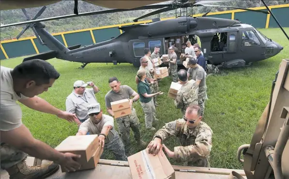  ??  ?? Soldiers from the Puerto Rico National Guard and others unload a helicopter carrying relief supplies Wednesday in Jayuya, Puerto Rico.