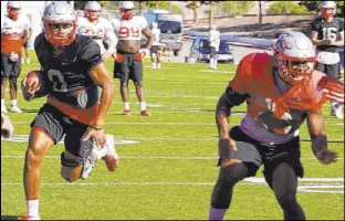  ?? Frank Mercoglian­o ?? QB Tevaka Tuioti, left, and his Lobo teammates have made Sam Boyd Stadium their home base amid a COVID-19 surge in Albuquerqu­e.