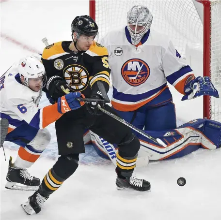  ?? CHRISTOPHE­R EVANS / BOSTON HERALD ?? MUCKING IT UP: Sean Kuraly of the Bruins tries to get a shot off against Islanders Ryan Pulock (6) and Robin Lehner during the first period at TD Garden on Thursday.