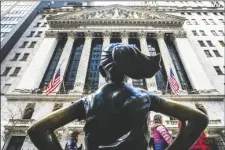  ?? AP PHOTO/EDUARDO MUNOZ ALVAREZ ?? People pass the Fearless Girl statue in front of the New York Stock Exchange in New York on Tuesday.