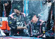  ?? AP PHOTO BY MATT BELL ?? Clint Bowyer, right, celebrates with his crew after winning a NASCAR Cup Series auto race at Martinsvil­le Speedway in Martinsvil­le, Va., Monday.