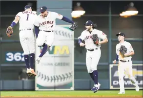  ?? Associated Press ?? Astros shortstop Carlos Correa (1), outfielder George Springer (4), outfielder Jake Marisnick (6) and Myles Straw (26) celebrate the win in Game 2 Saturday.