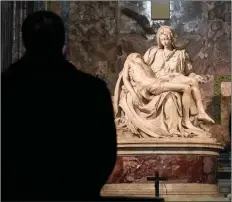  ?? (AP/Andrew Medichini) ?? Visitors admire the marble sculpture “The Pietà,” made in 1499 by Italian sculptor Michelange­lo Buonarroti, inside St. Peter’s Basilica, at the Vatican.