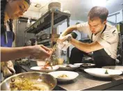  ?? Mark Mulligan / Houston Chronicle ?? Executive chef William Wright and line cook Mercedes Gomez assemble dishes at Helen Greek Food & Wine, nominated as one of the nation’s best new restaurant­s.