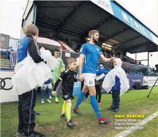  ??  ?? MACC WEATHER Stormy times as Fiacre Kelleher leads out his team