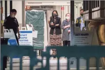  ?? Damian Dovarganes / Associated Press ?? Former first lady and former U.S. Secretary of State Hillary Clinton, center right, closes her coat as she exits the University of California Irvine Medical Center before midnight in Orange, Calif., Thursday. Former President Bill Clinton was admitted to the Southern California hospital Tuesday with an infection but he is “on the mend,” his spokesman said.