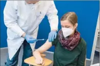  ?? (AFP) ?? A healthcare worker receives an injection with the AstraZenec­a COVID-19 vaccine at the university hospital in Halle, Germany, on Friday.