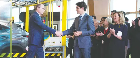  ??  ?? Toyota Canada president Fred Volf, left, greets PM Justin Trudeau at the Toyota plant in Cambridge, where Toyota announced it will make the new Lexus NX luxury SUV.