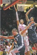  ?? JIM THOMPSON THE ALBUQUERQU­E JOURNAL VIA AP ?? New Mexico’s Anthony Mathis, center, takes the ball to the basket against Utah State’s Dwayne Brown Jr., right, and Sam Merrill during Wednesday’s game in Albuquerqu­e.
