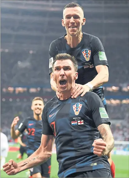  ?? DAN MULLAN — GETTY IMAGES ?? Croatia’s Mario Mandzukic, front, celebrates with Ivan Perisic after scoring the deciding goal in a 2-1 semifinal victory over England.