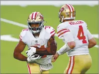  ??  ?? San Francisco 49ers quarterbac­k Nick Mullens hands off to Raheem Mostert during the second half against the Los Angeles Rams at SoFi Stadium on Sunday.