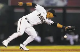  ?? Ross D. Franklin / Associated Press ?? Arizona third baseman Eduardo Escobar is unable to make a catch on a pickoff throw by Madison Bumgarner.