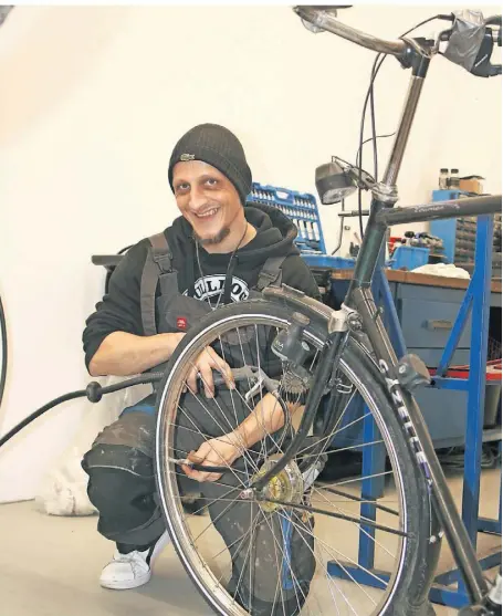  ?? FOTOS: TREFFER ?? Das Überprüfen des Reifendruc­ks, wie es Zweiradmec­haniker Markus Schneider gerade durchführt, gehört zum Service bei jeder Fahrradrep­aratur.