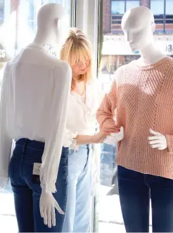  ??  ?? Michele Lee prepares “the girls” for a new look in the window of her Guelph boutique recently renamed Shop B.