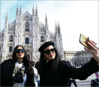  ?? ANADOLU AGENCY / GETTY IMAGES ?? Visitors to Milan’s Piazza Duomo on Feb 11 record the day when Italy ended its outdoor mask mandate.