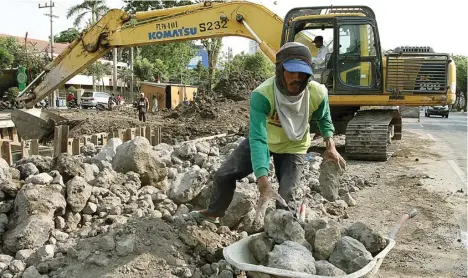  ?? ROBERTUS RISKY/JAWA POS ?? KEJAR TARGET: Para pekerja dengan dibantu ekskavator menyelesai­kan proyek dan pelebaran saluran di Jalan Prapen kemarin.