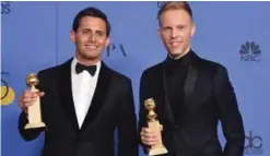  ??  ?? Songwritin­g duo Benj Pasek (left) and Justin Paul pose with the trophy for Best Original Song - Motion Picture.