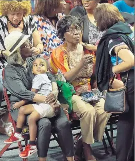  ?? Chip Somodevill­a Getty Images ?? FAMILY MEMBERS of victims of Wednesday night’s mass shooting at Emanuel AME Church gather for a prayer vigil at an arena in Charleston.