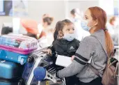  ?? AL SEIB/LOS ANGELES TIMES 2020 ?? Karen Alvarez and her 3-year-old daughter Mercedez Gomez wear face masks at Los Angeles Internatio­nal Airport before their flight to Nicaragua.