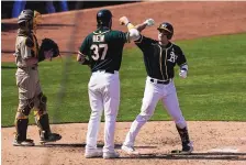  ?? JEFF CHIU/ASSOCIATED PRESS ?? Oakland’s Ramon Laureano, right, is congratula­ted by Jonah Hein (37) after hitting a two-run homer in the sixth inning against visiting San Diego on Saturday.