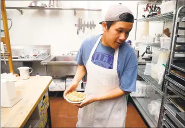  ?? PHOTOS BY ARIC CRABB — STAFF PHOTOGRAPH­ER ?? Employee-owner Toto Chittharat­h works in the bakery of the Niles Pie Company, which transition­ed from single ownership.