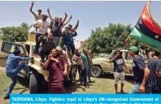  ?? — AFP ?? TARHOUNA, Libya: Fighters loyal to Libya’s UN-recognized Government of National Accord pose for a group picture as they celebrate in this town on Friday after the area was taken over by pro-GNA forces.