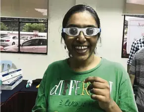  ??  ?? Shaarini is happy as a lark as she tries out a pair of goggles for the visually impaired. — MAJORIE CHIEW/The Star