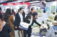  ?? PROVIDED TO CHINA DAILY ?? Visitors choose specialty products at an exhibition during the congress.