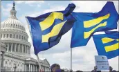  ?? JACQUELYN MARTIN — THE ASSOCIATED PRESS FILE ?? People with the Human Rights Campaign hold up “equality flags” during an event on Capitol Hill in Washington in support of transgende­r members of the military.