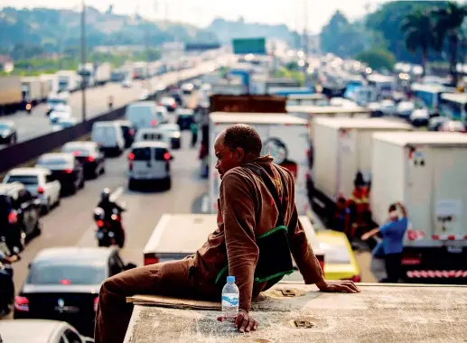  ??  ?? Il blocco Un autista di un camion seduto sul tetto del suo tir, fermo sull’autostrada Washington Luiz a Duque de Caxias, a nord di Rio de Janeiro, nel quinto giorno di proteste