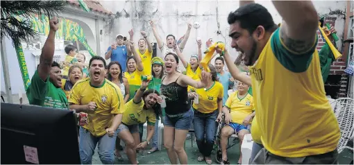  ?? MARTIN MEJIA/ THE ASSOCIATED PRESS ?? Soccer fans in Manaus celebrate as they watch the second goal scored by Brazilian striker Neymar in the World Cup opening match against Croatia on Thursday.