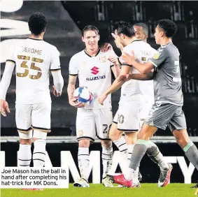  ??  ?? Joe Mason has the ball in hand after completing his hat-trick for MK Dons.