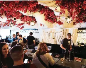  ??  ?? Spread across the ceiling above the bar counter are the mighty white branches and red leaves of a Weirwood.