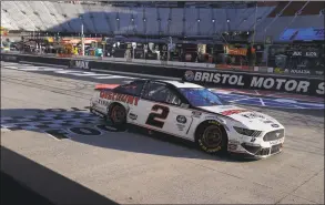  ?? Kevin C. Cox / Getty Images ?? Brad Keselowski cross the finish line to win the Food City presents the Supermarke­t Heroes 500 at Bristol Motor Speedway on Sunday in Bristol, Tenn.