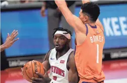  ?? CARLOS OSORIO/AP ?? Detroit Pistons forward Jerami Grant drives on Phoenix Suns guard Devin Booker (1) during overtime Friday in Detroit.
