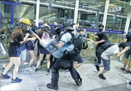  ?? / T. PETER (REUTERS) ?? Enfrentami­entos entre policías y manifestan­tes, ayer en el aeropuerto de Hong Kong.