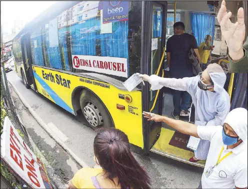  ?? KRIZJOHN ROSALES ?? Personnel clad in protective equipment man a vehicle deployed for the Metro Rail Transit Line 3’s bus augmentati­on program at its Taft Avenue station yesterday. The MRT-3 suspended operations due to a surge in COVID-19 cases among the rail line’s employees. Related story on Page 6.