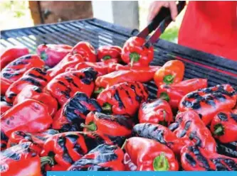  ??  ?? A Bosnian woman bakes red peppers to prepare ajvar.