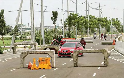  ?? DIMAS MAULANA/JAWA POS ?? BELUM DIBUKA UNTUK UMUM: Sebuah mobil melewati sisi barat JLLT seksi Kedung Cowek yang dipasangi barier dan box culvert di tengah jalan kemarin.